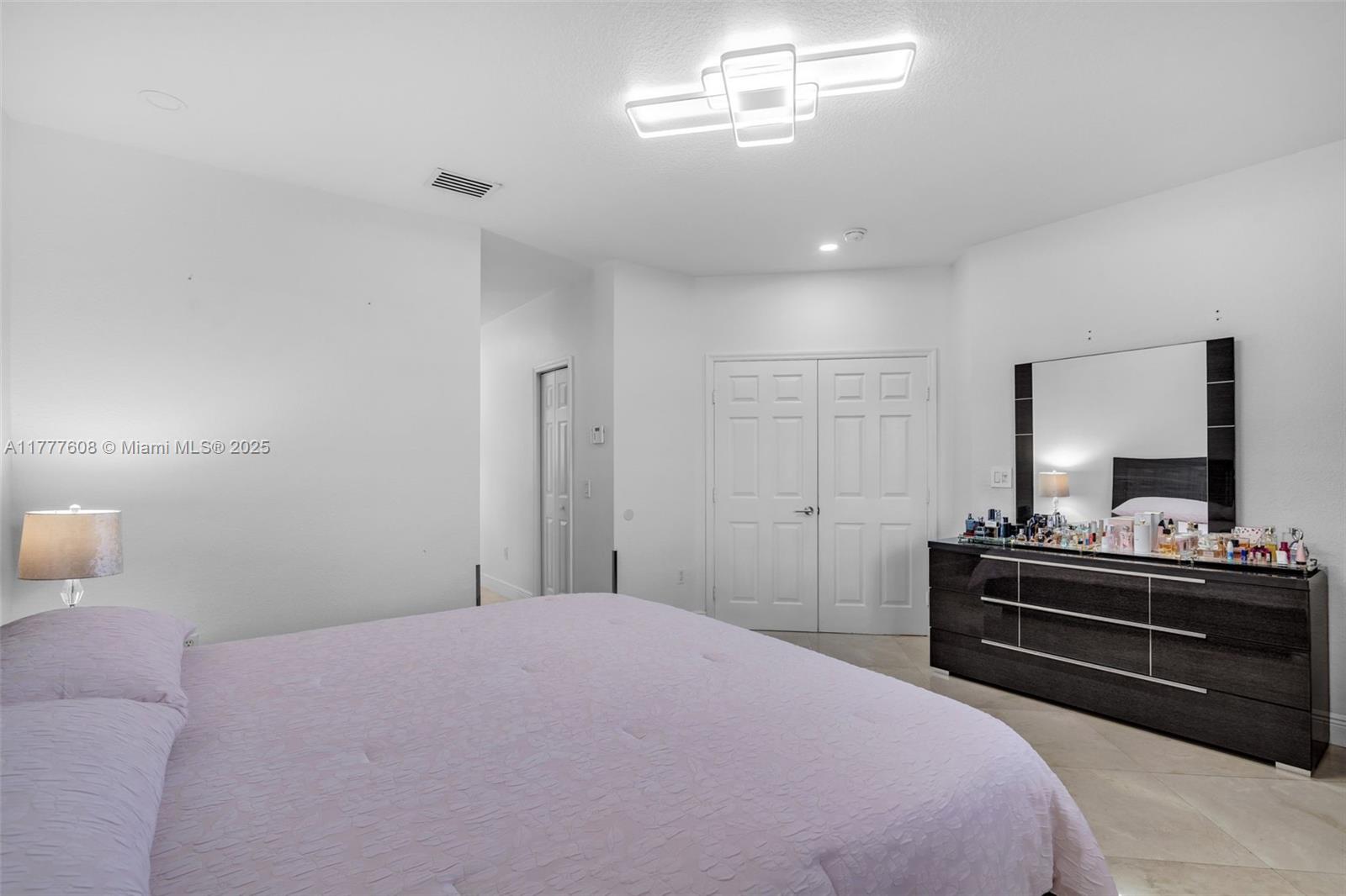 16075 Southwest 149th Terrace Miami, FL 33196 - Photo 19 of 46 a bedroom with a bed and a chandelier