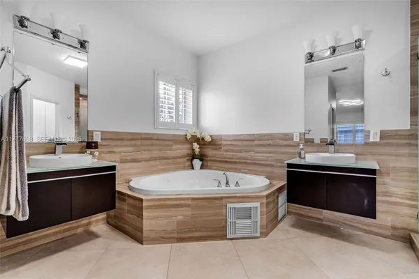 a spacious bathroom with a tub sink and mirror