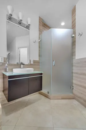 a bathroom with a bathtub sink vanity granite and shower