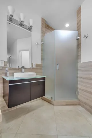 a bathroom with a bathtub sink vanity granite and shower