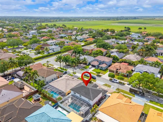 an aerial view of residential houses with outdoor space and swimming pool