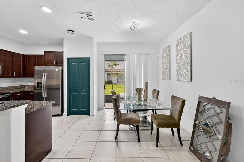 14446 Editors Note Street Ruskin, FL 33573 - Photo 17 of 52 a dining room with furniture a large window and a refrigerator