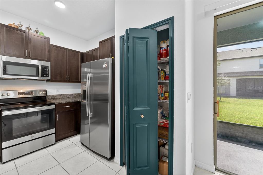 14446 Editors Note Street Ruskin, FL 33573 - Photo 18 of 52 a kitchen with stainless steel appliances granite countertop a refrigerator and a stove top oven