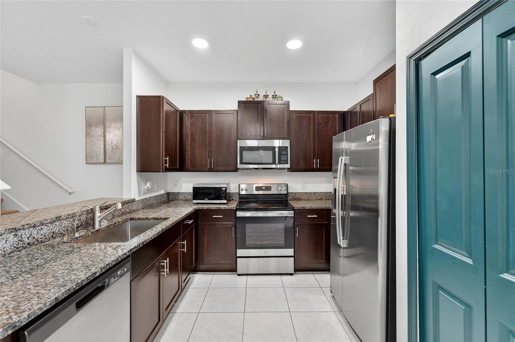 14446 Editors Note Street Ruskin, FL 33573 - Photo 22 of 52 a kitchen with stainless steel appliances granite countertop a refrigerator and a sink