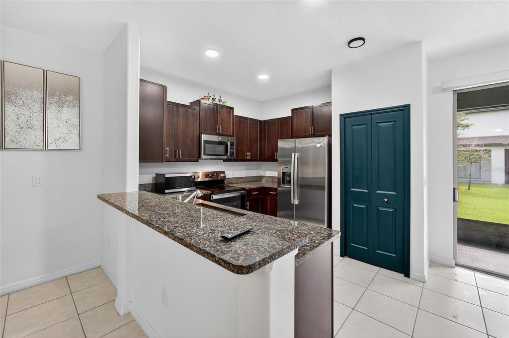 14446 Editors Note Street Ruskin, FL 33573 - Photo 25 of 52 a kitchen with stainless steel appliances granite countertop a refrigerator and a sink