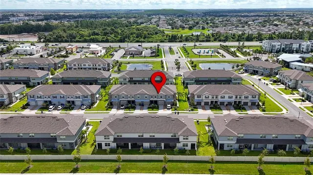 an aerial view of a city with lots of residential buildings and parking space