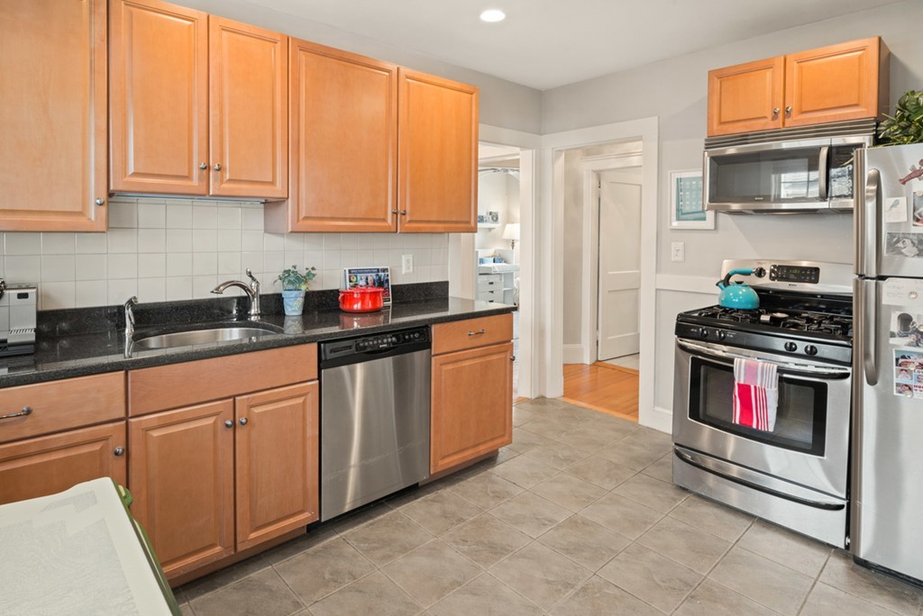 89-91 Elm Road, Unit 1 Newton, MA 02460 - Photo 6 of 18 a kitchen with stainless steel appliances granite countertop a stove a sink and a refrigerator