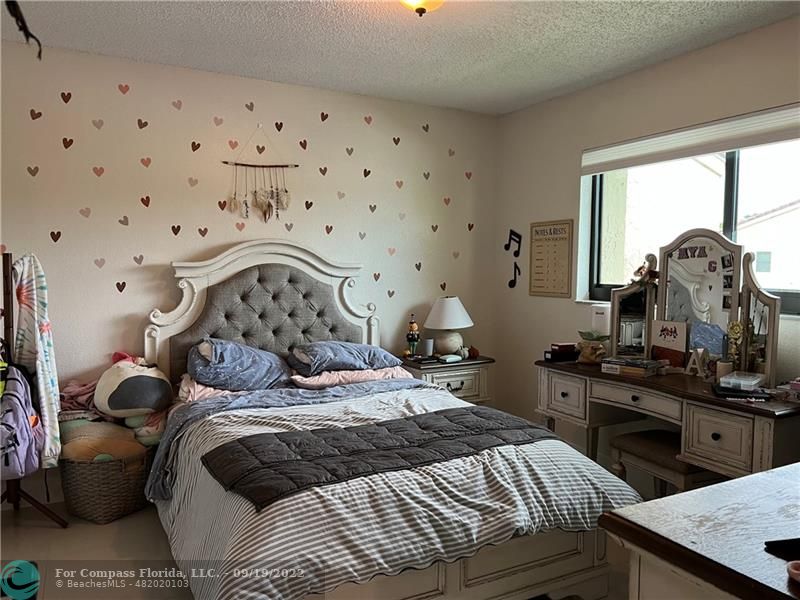 22465 Southwest 61st Way, Unit 241 Boca Raton, FL 33428 - Photo 13 of 18 a bedroom with a bed and a chandelier