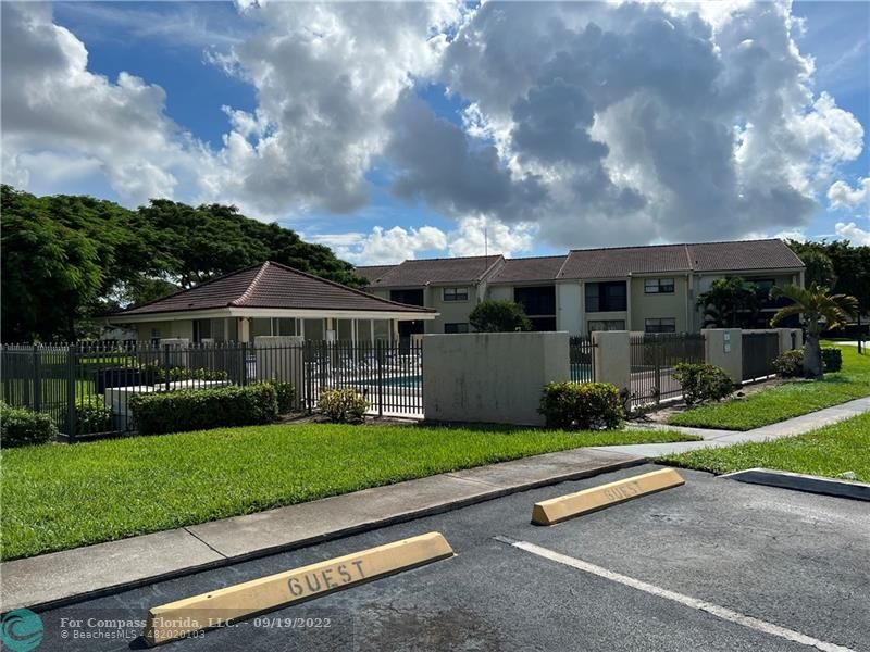 22465 Southwest 61st Way, Unit 241 Boca Raton, FL 33428 - Photo 17 of 18 a view of a house with a big yard potted plants and a large tree