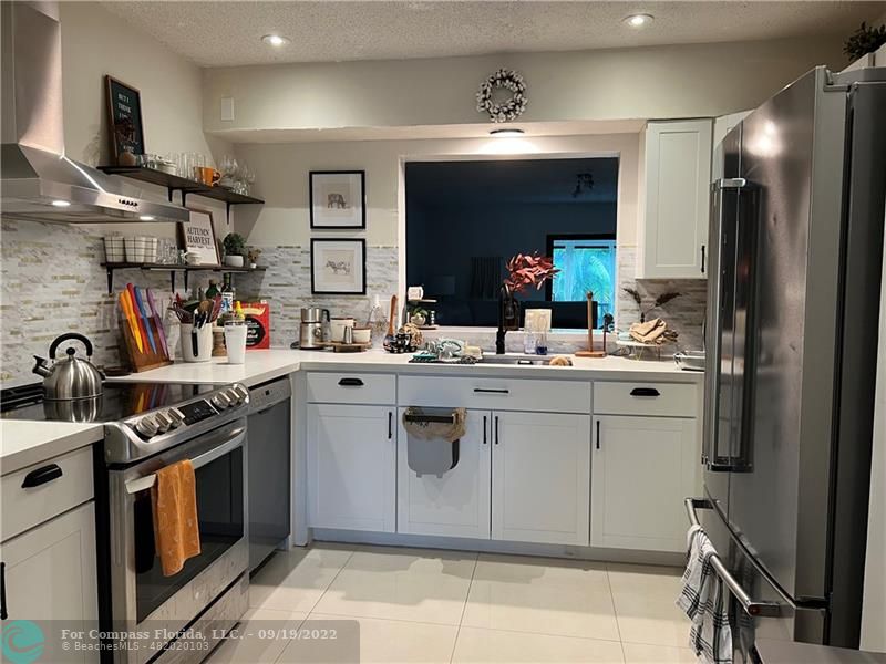 22465 Southwest 61st Way, Unit 241 Boca Raton, FL 33428 - Photo 2 of 18 a kitchen with a sink stove and cabinets