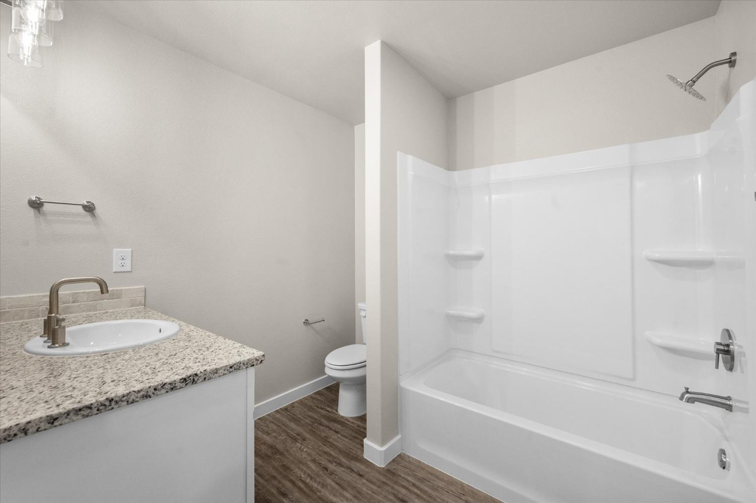 1608 142nd Street Lubbock, TX 79423 - Photo 15 of 20 a bathroom with a granite countertop sink a toilet and bathtub