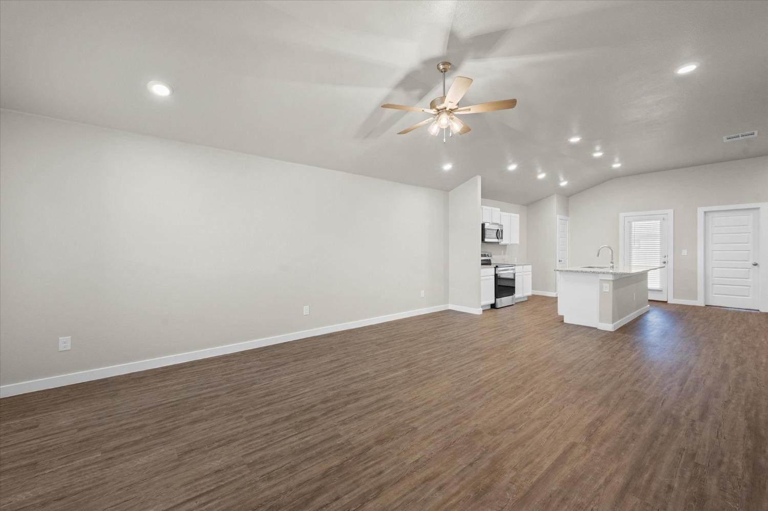 1608 142nd Street Lubbock, TX 79423 - Photo 3 of 20 wooden floor in an empty room with a kitchen
