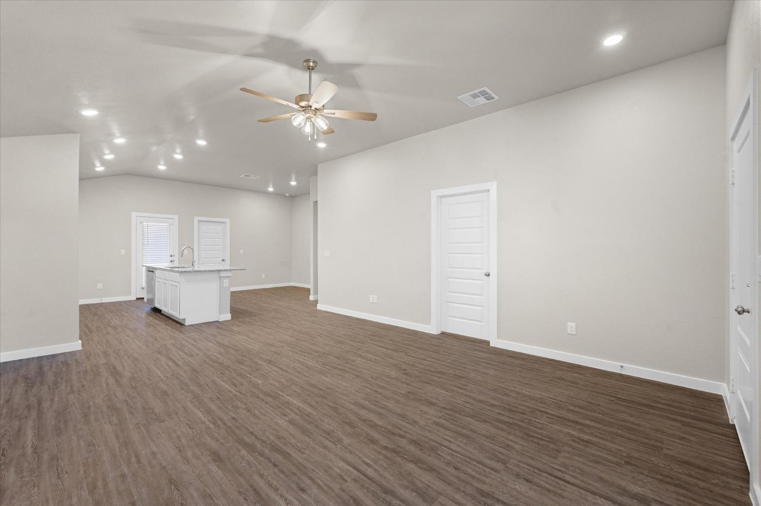 1608 142nd Street Lubbock, TX 79423 - Photo 4 of 20 a view of a livingroom with a ceiling fan wooden floor and kitchen