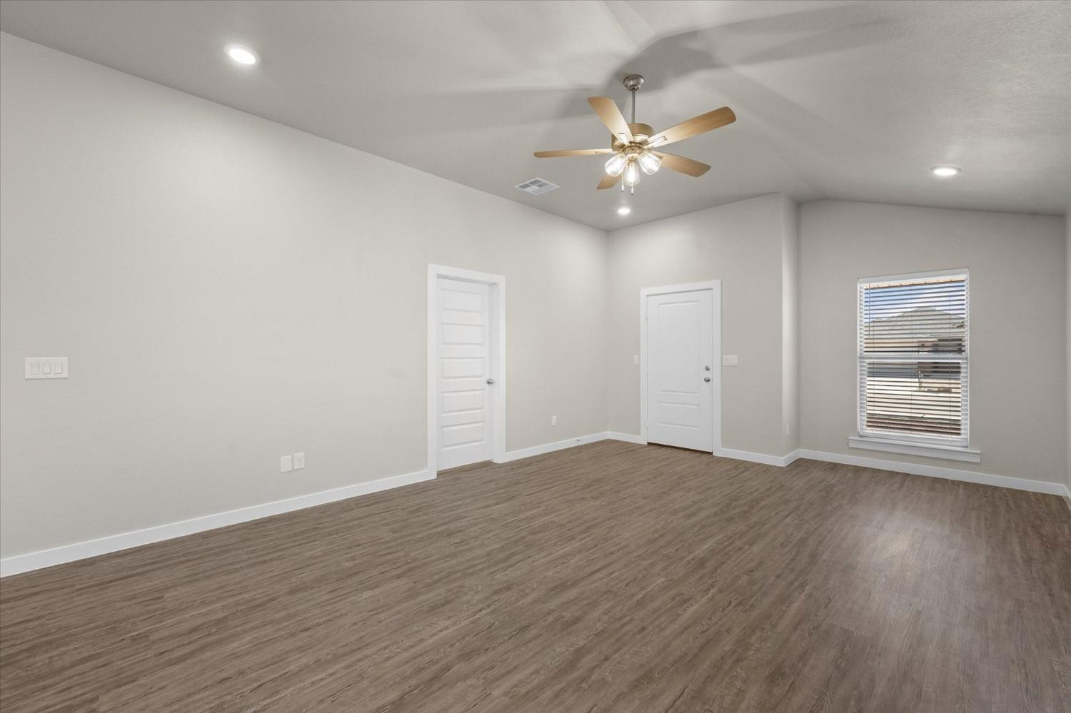 1608 142nd Street Lubbock, TX 79423 - Photo 5 of 20 a view of an empty room with wooden floor and a ceiling fan