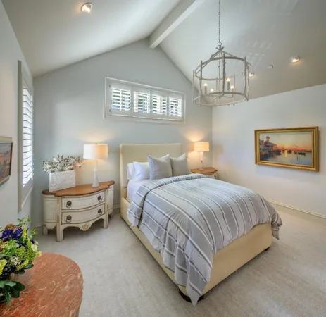 a spacious bedroom with a bed and a chandelier