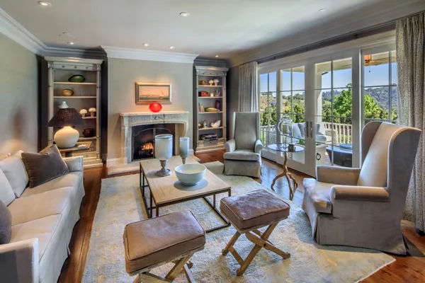 a living room with furniture fireplace and a large window