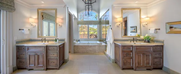 a spacious bathroom with a granite countertop sink a mirror and a bathtub