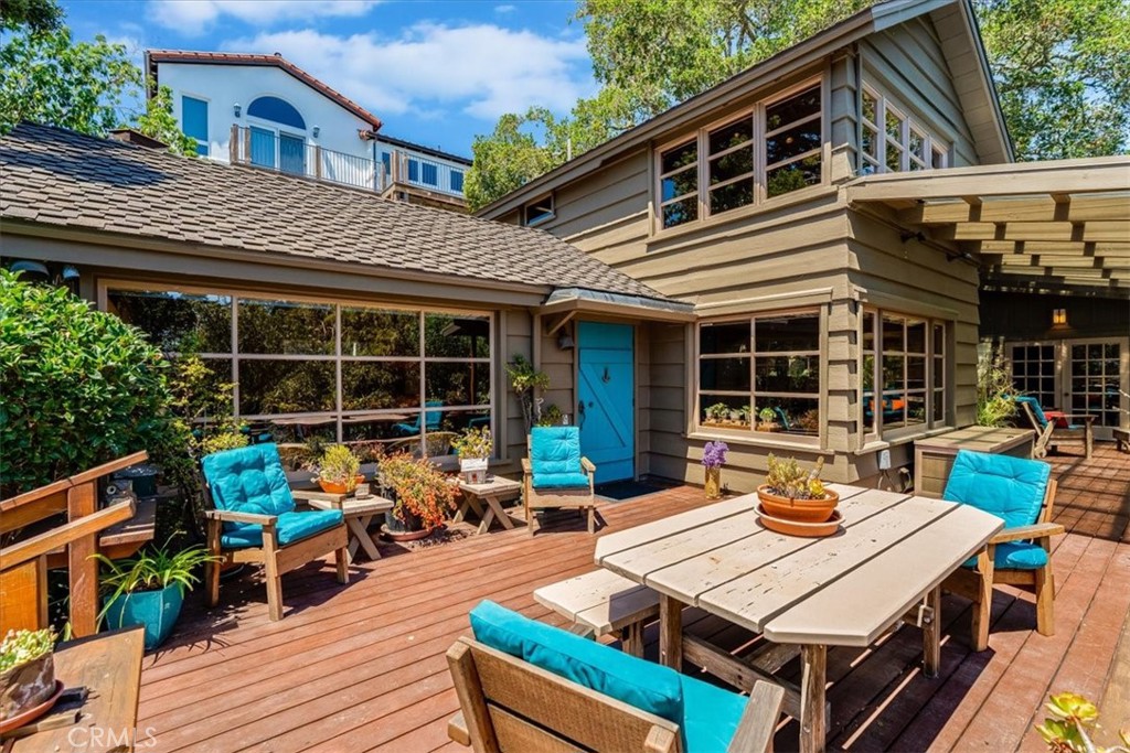 a view of a patio with table and chairs with wooden floor and fence