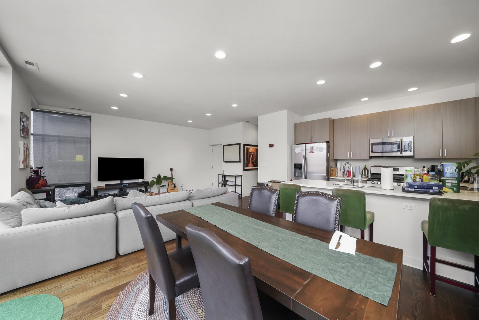 832 West Erie Street, Unit 4W Chicago, IL 60642 - Photo 2 of 8 a living room with stainless steel appliances a dining table wooden floor windows and a kitchen view
