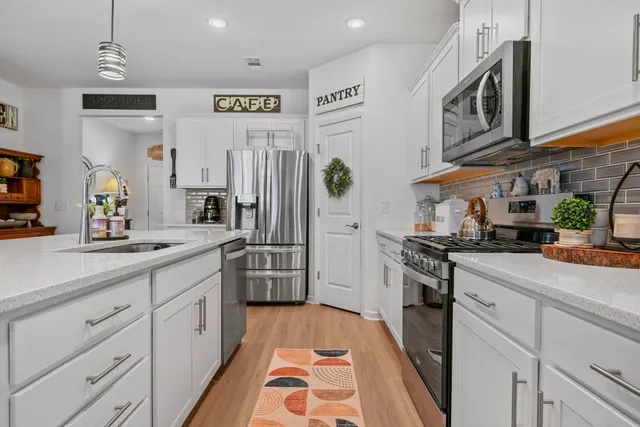 a kitchen with stainless steel appliances a sink stove and a refrigerator