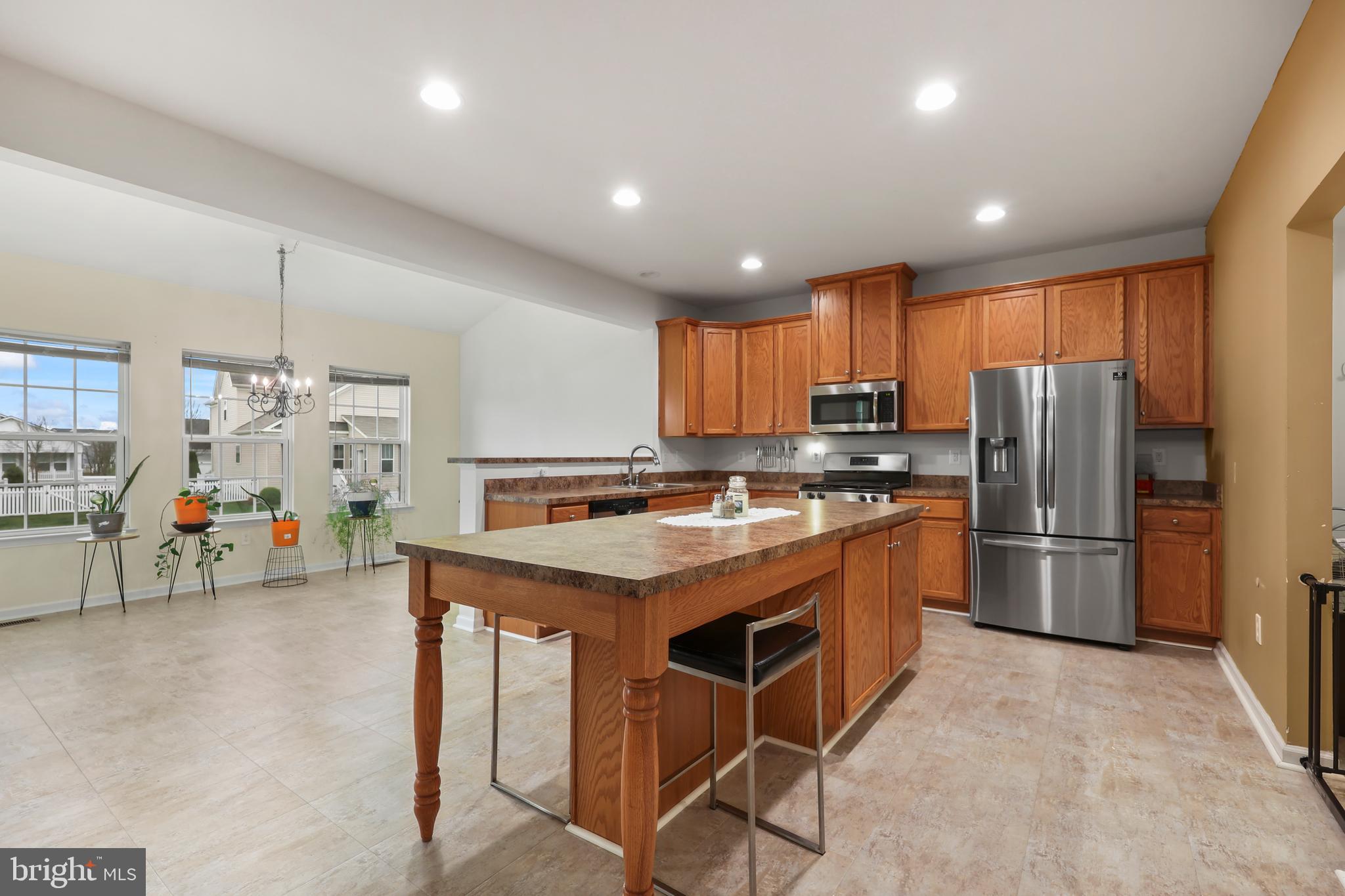 112 Northumberland Drive Stephenson, VA 22656 - Photo 12 of 58 a kitchen with refrigerator a stove a sink a dining table and chairs