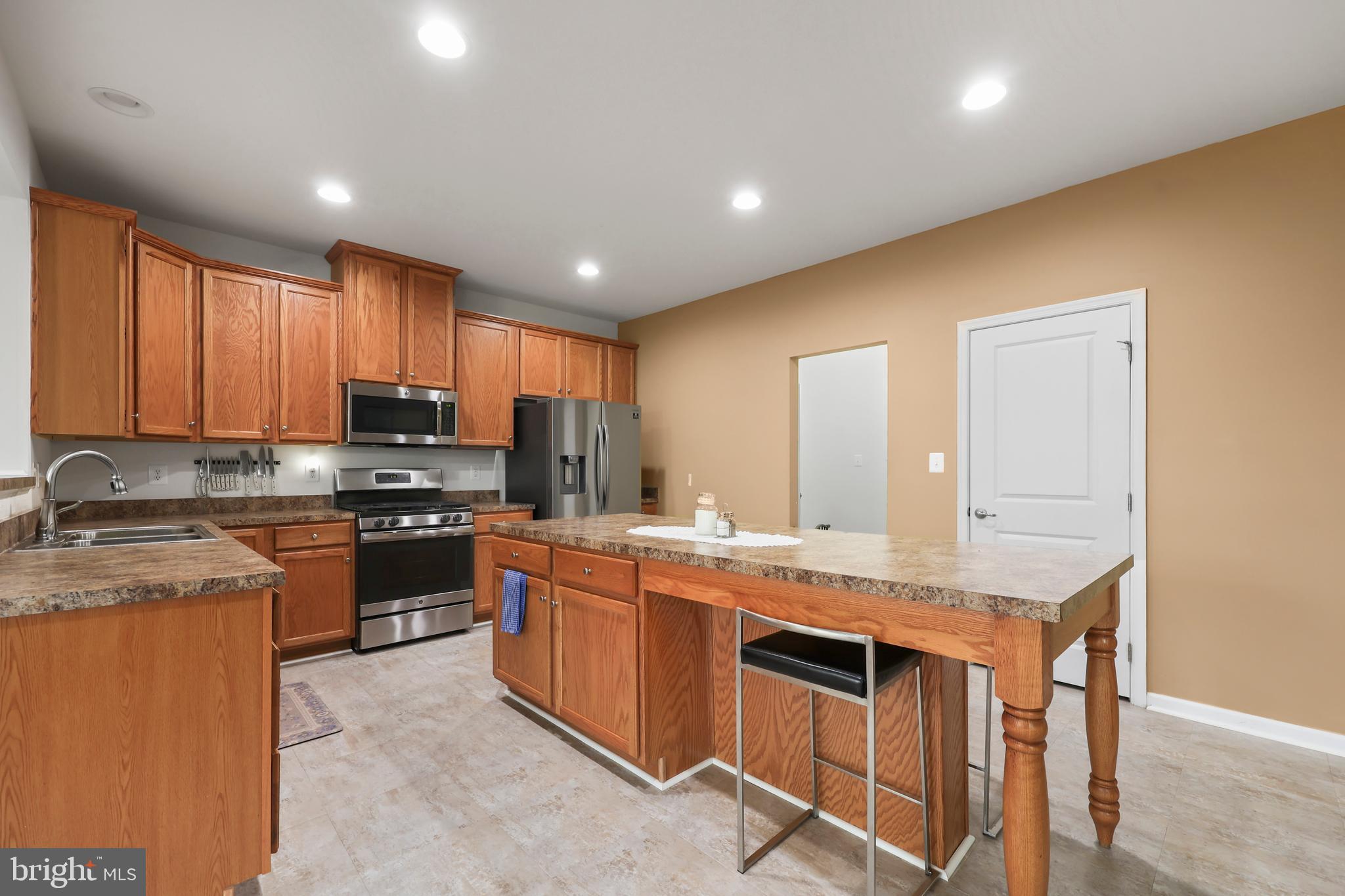 112 Northumberland Drive Stephenson, VA 22656 - Photo 13 of 58 a kitchen with a stove a sink a microwave a center island and furniture