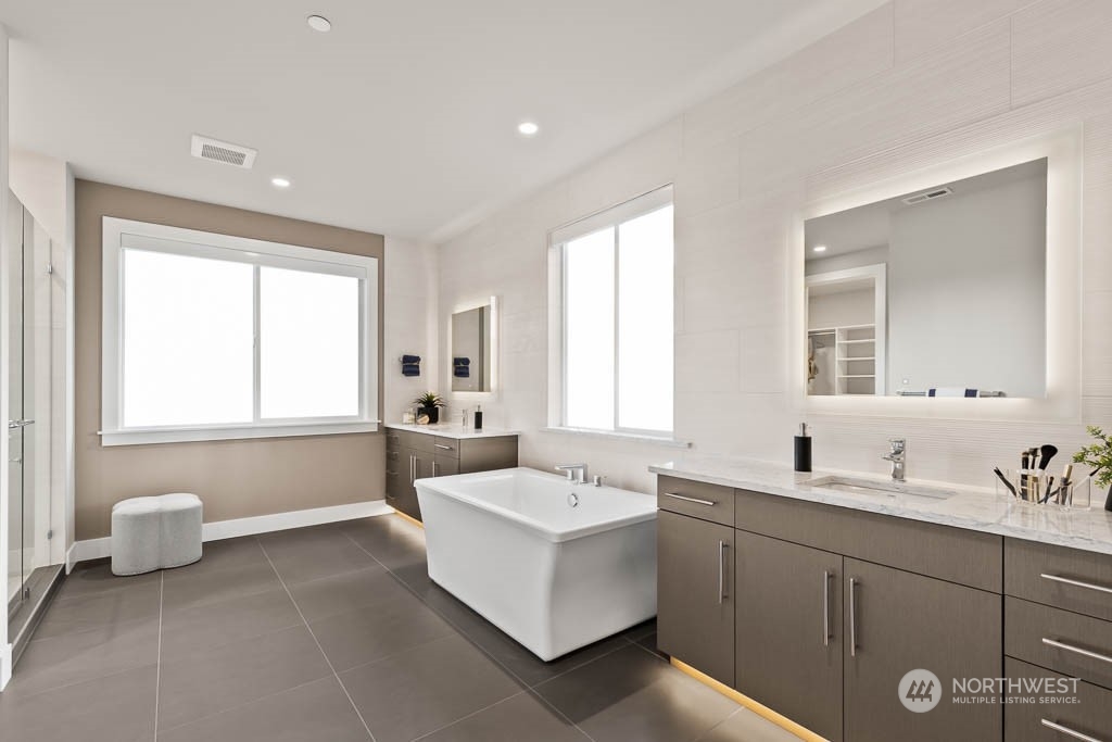 933 131st Place Northeast, Unit 4 Bellevue, WA 98005 - Photo 13 of 18 a spacious bathroom with a double vanity sink a mirror and a bathtub