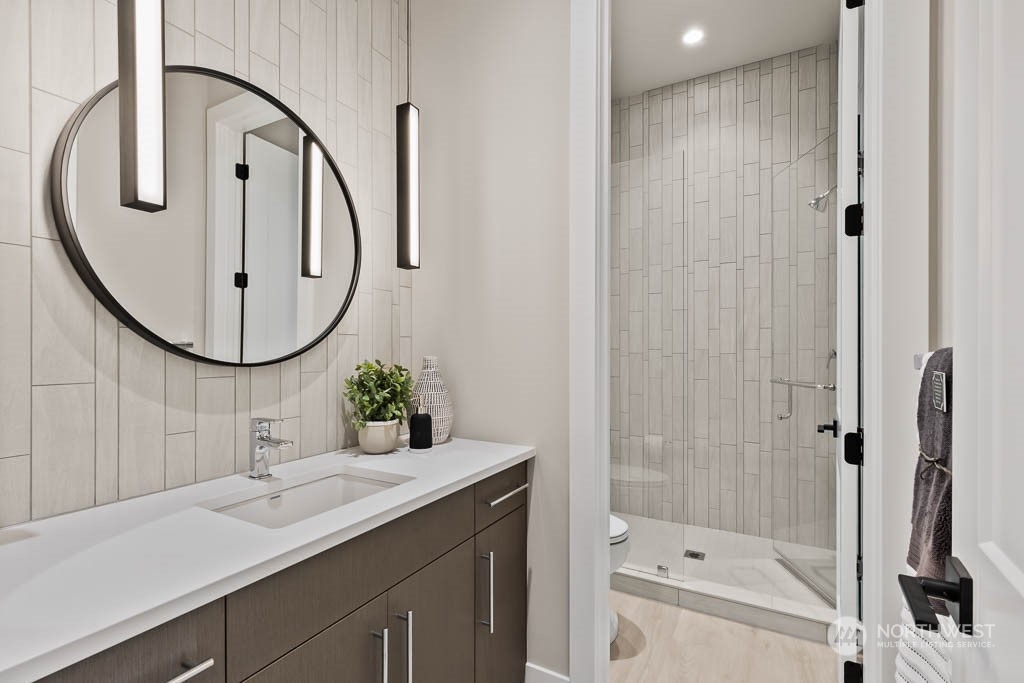 933 131st Place Northeast, Unit 4 Bellevue, WA 98005 - Photo 8 of 18 a bathroom with a sink vanity granite and a mirror