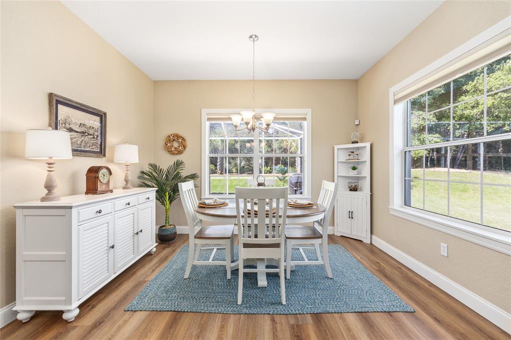 19639 Southwest 77th Loop Dunnellon, FL 34432 - Photo 24 of 59 a dining room with furniture a chandelier and wooden floor