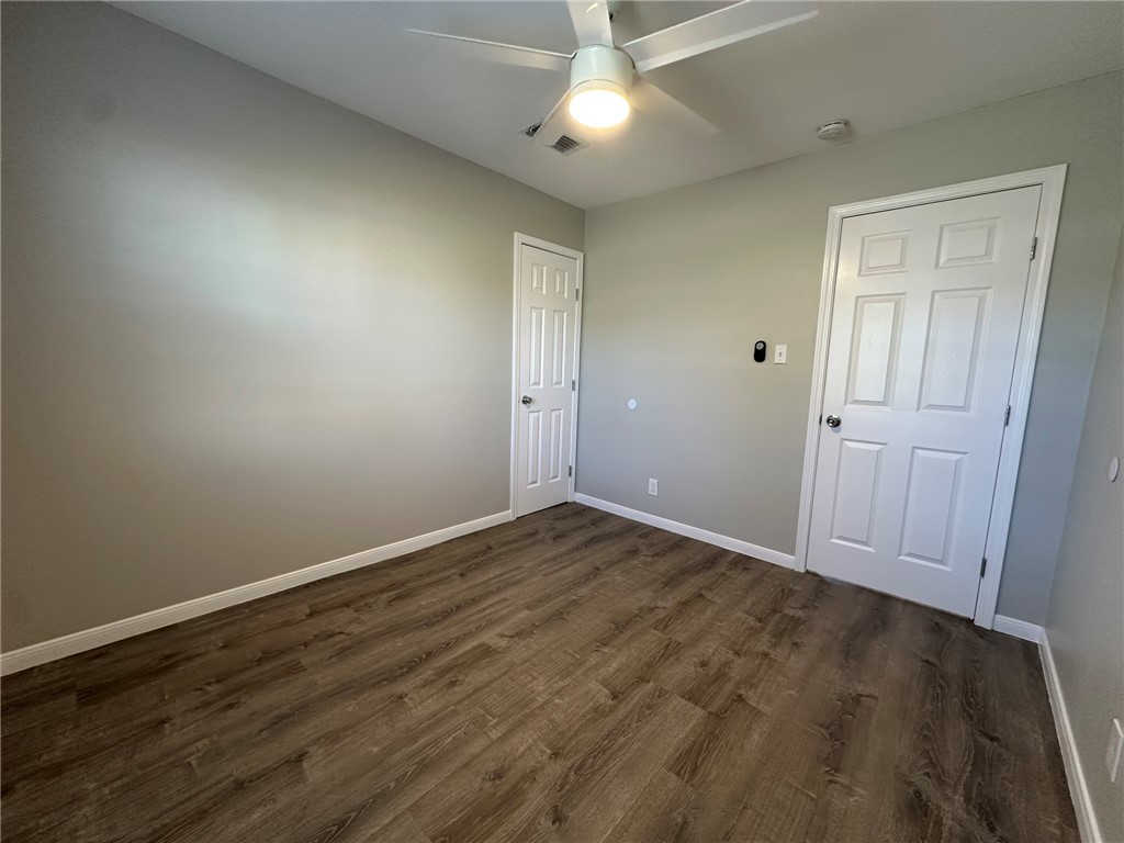 3152 Meadow Lane Robstown, TX 78380 - Photo 15 of 40 an empty room with wooden floor ceiling fan and windows