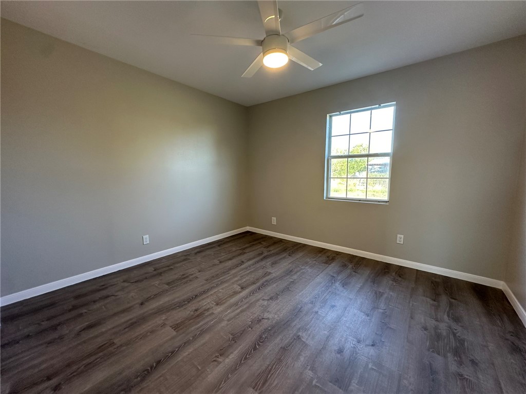 3152 Meadow Lane Robstown, TX 78380 - Photo 18 of 40 an empty room with wooden floor and windows