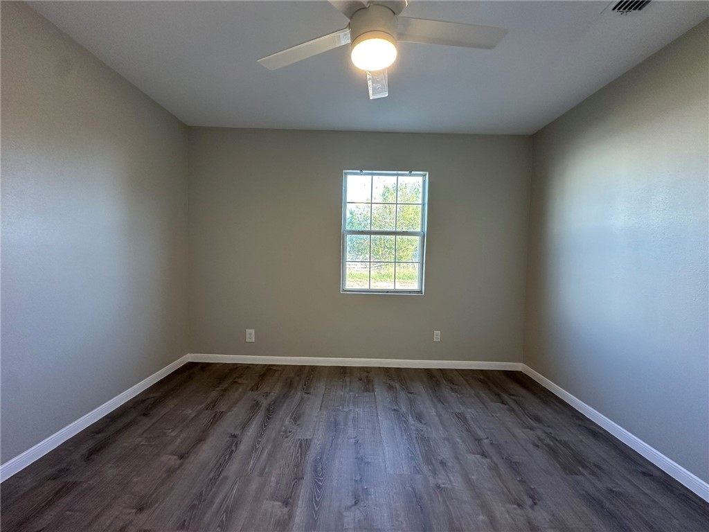3152 Meadow Lane Robstown, TX 78380 - Photo 19 of 40 an empty room with wooden floor and windows
