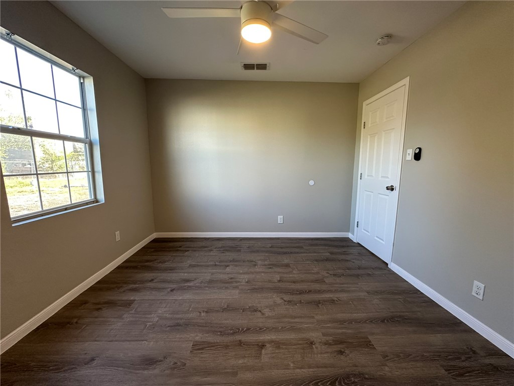 3152 Meadow Lane Robstown, TX 78380 - Photo 21 of 40 an empty room with wooden floor and windows