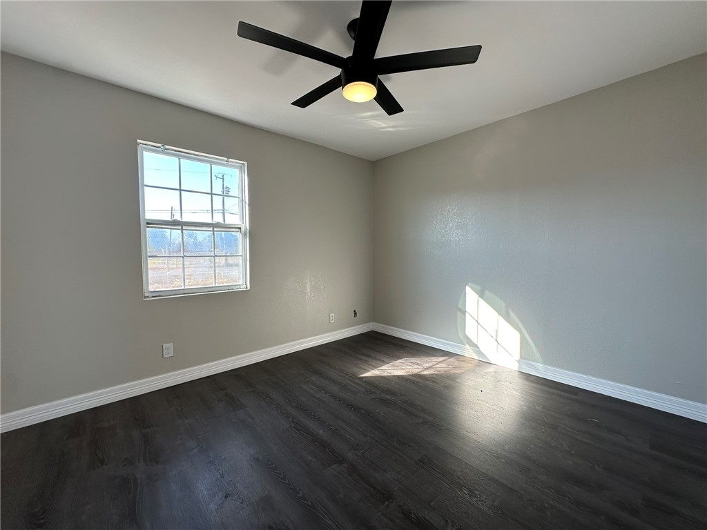 3152 Meadow Lane Robstown, TX 78380 - Photo 25 of 40 an empty room with wooden floor and windows
