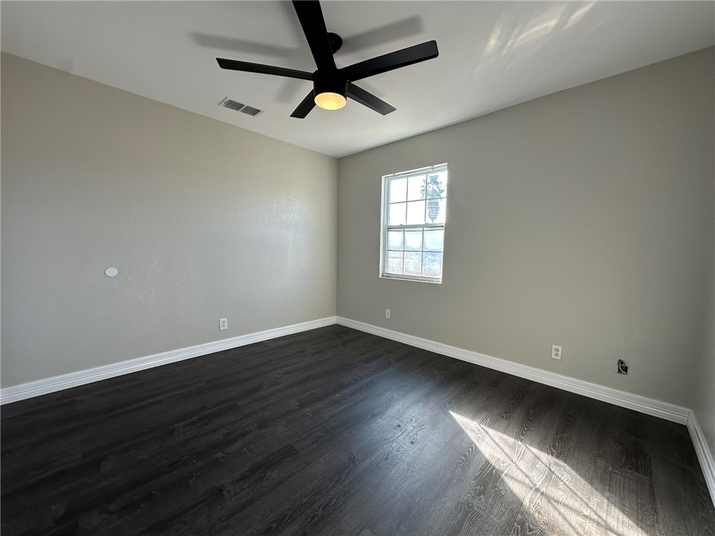 3152 Meadow Lane Robstown, TX 78380 - Photo 27 of 40 an empty room with wooden floor and windows