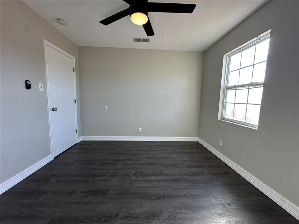 3152 Meadow Lane Robstown, TX 78380 - Photo 28 of 40 an empty room with wooden floor cabinet and windows