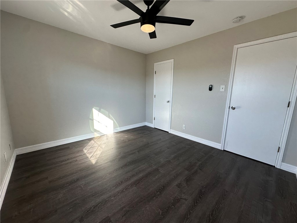 3152 Meadow Lane Robstown, TX 78380 - Photo 31 of 40 an empty room with wooden floor a ceiling fan and a window