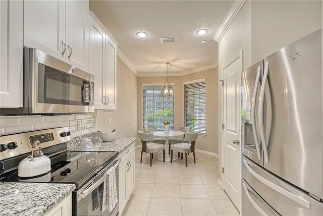 a kitchen with stainless steel appliances granite countertop a refrigerator stove microwave and sink