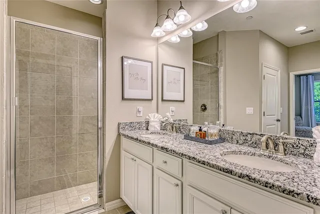 a bathroom with a granite countertop sink a large mirror and a shower