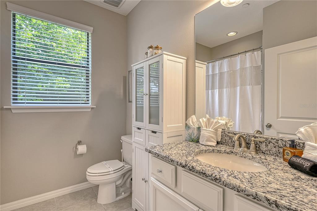 5420 Cicerone Street, Unit 101 Sarasota, FL 34238 - Photo 21 of 40 a bathroom with a granite countertop sink and a mirror