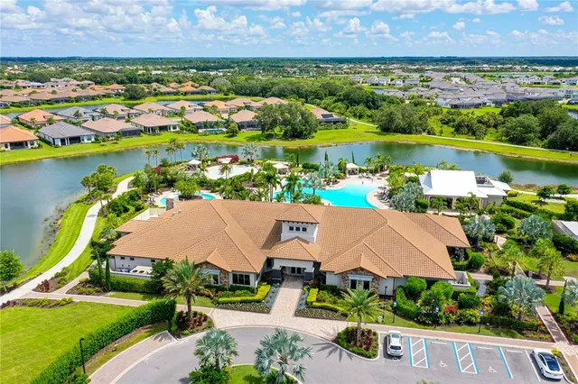 an aerial view of residential houses with outdoor space and lake view