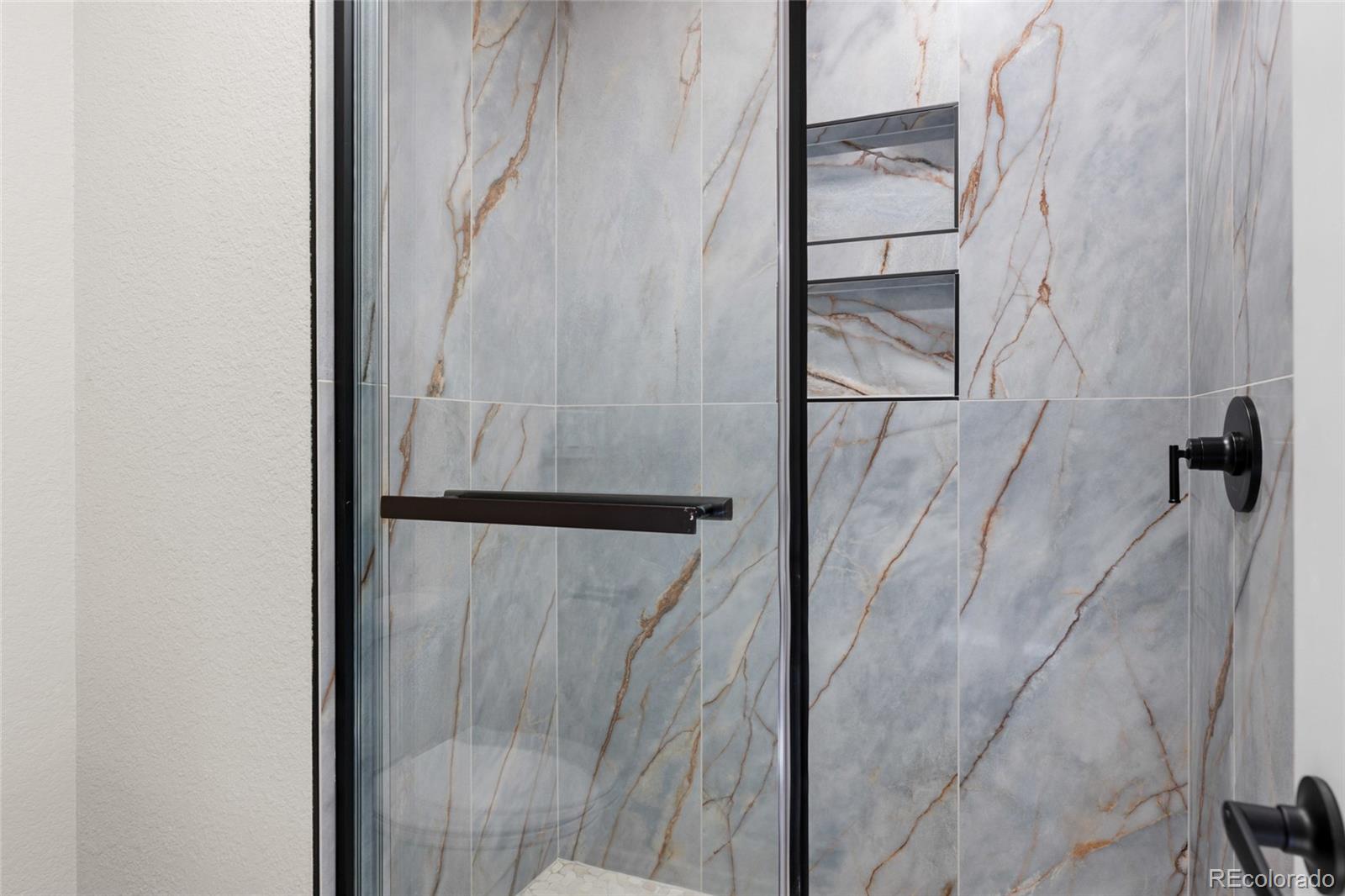 8205 Dudley Way Arvada, CO 80005 - Photo 16 of 44 a bathroom with a glass shower door