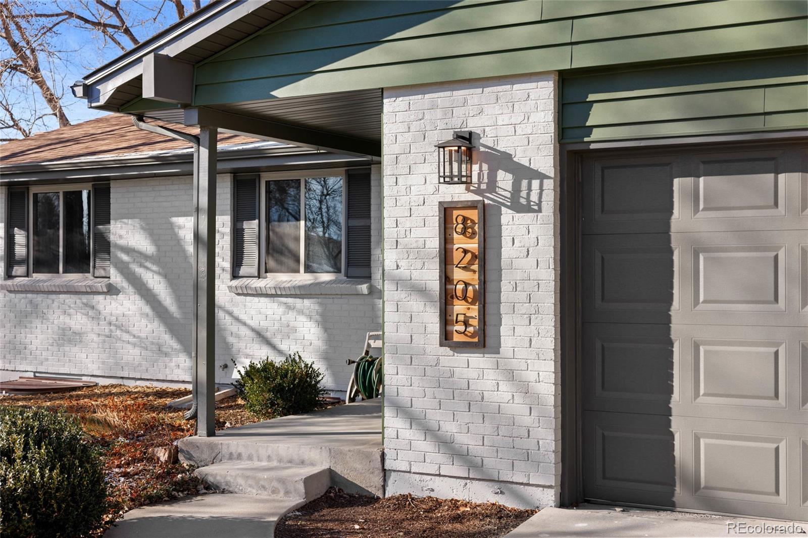 8205 Dudley Way Arvada, CO 80005 - Photo 2 of 44 a front view of a house with a garden