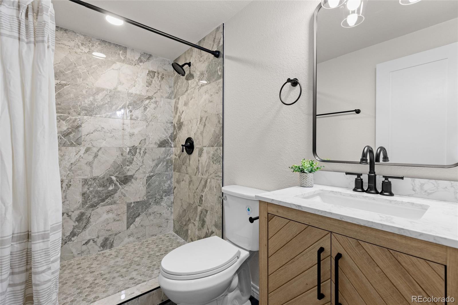 8205 Dudley Way Arvada, CO 80005 - Photo 28 of 44 a bathroom with a sink toilet and shower