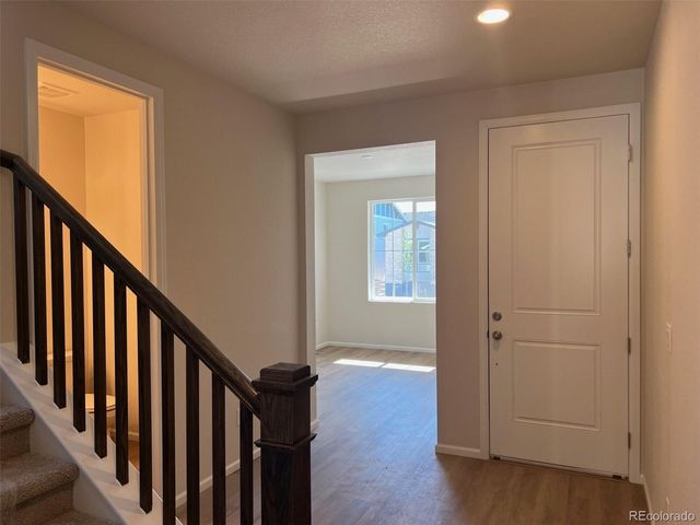 a view of a hallway with wooden floor and staircase