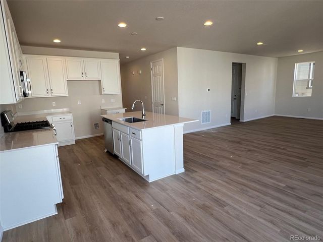 a kitchen with a sink and wooden floor