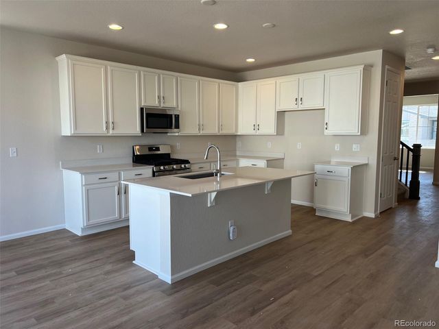 a kitchen with cabinets a sink and a stove top oven