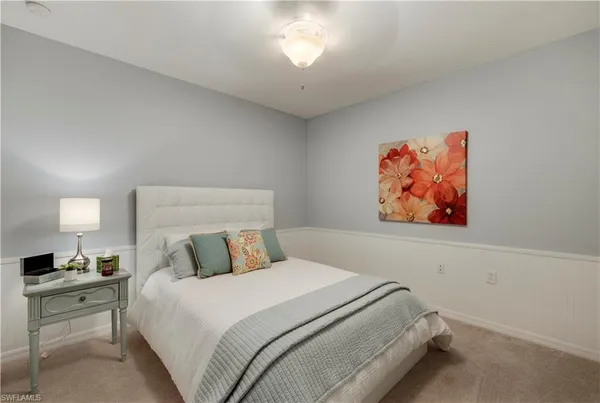 a bedroom with a bed and a painting on the wall