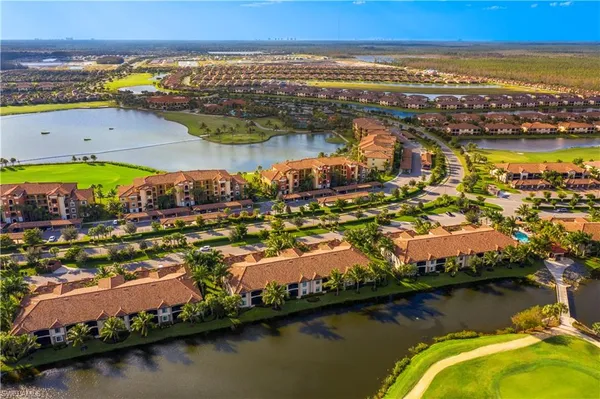 an aerial view of residential houses with outdoor space and ocean view
