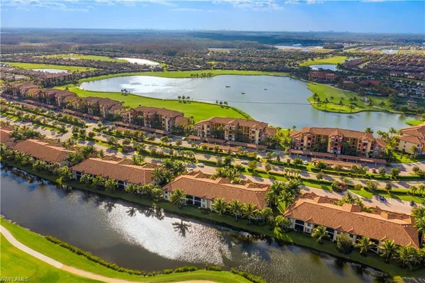 an aerial view of residential houses with outdoor space and lake view